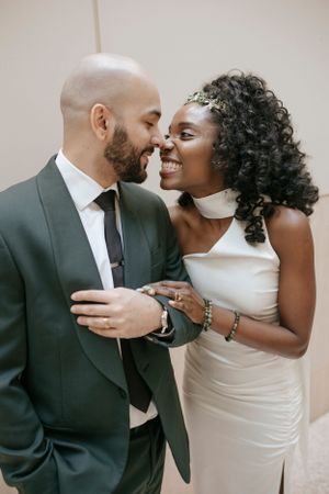 Loving couple sharing an intimate moment in their wedding attire at a courthouse.