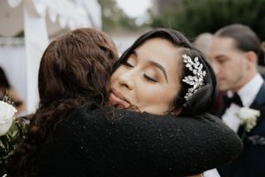 Tender embrace during emotional wedding celebration outdoors.