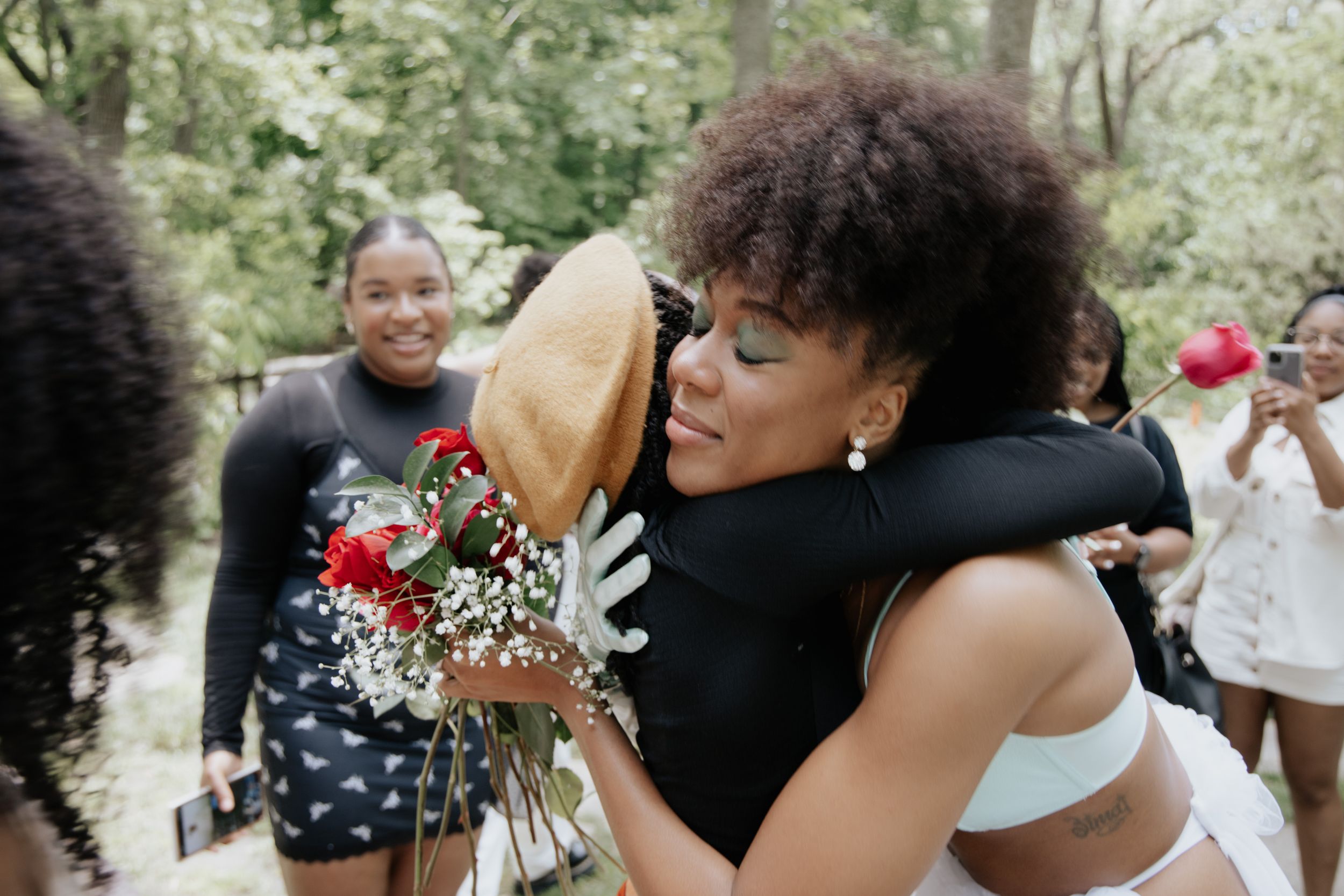 Emotional moment of celebration and hugging at an outdoor gathering.