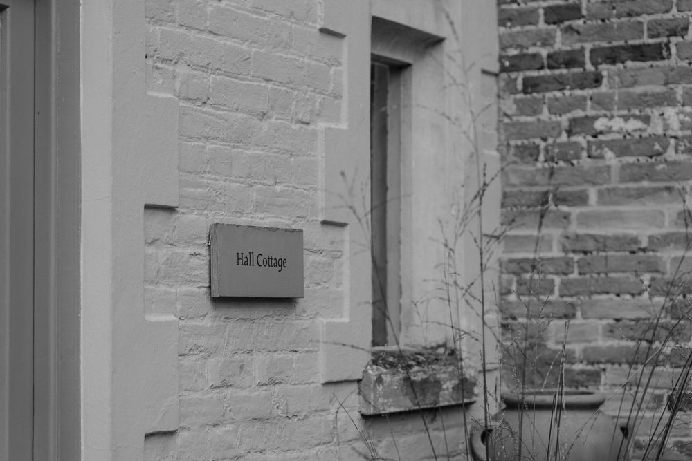 A wooden plaque on the wall of the cottage at oxnead hall in norfolk