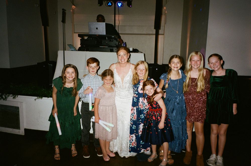 A group photo at a wedding celebration with people in formal attire.