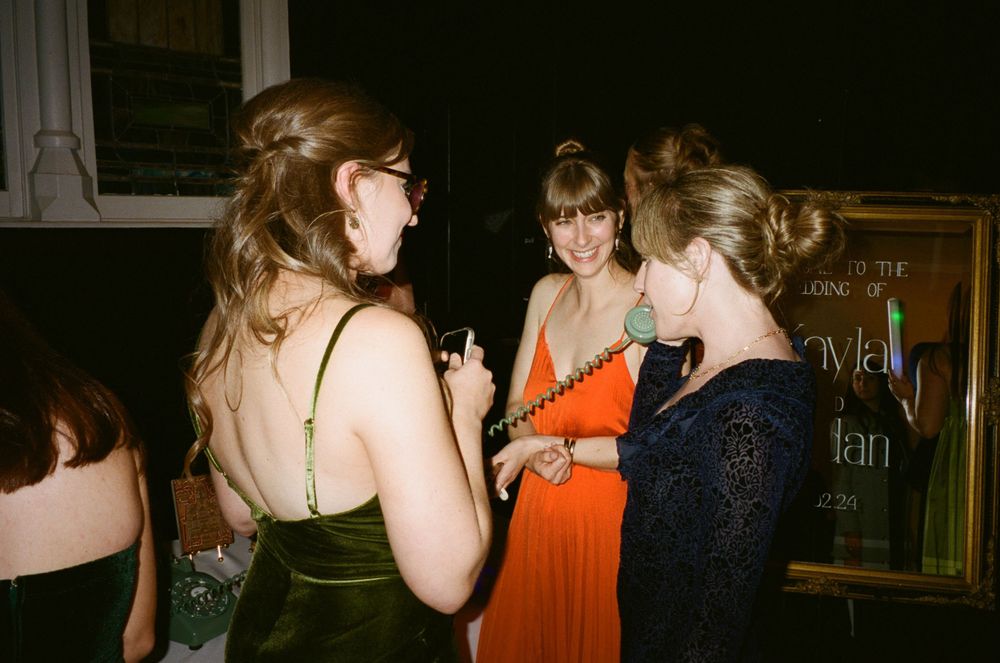 Guests in formal attire chatting at an evening event.