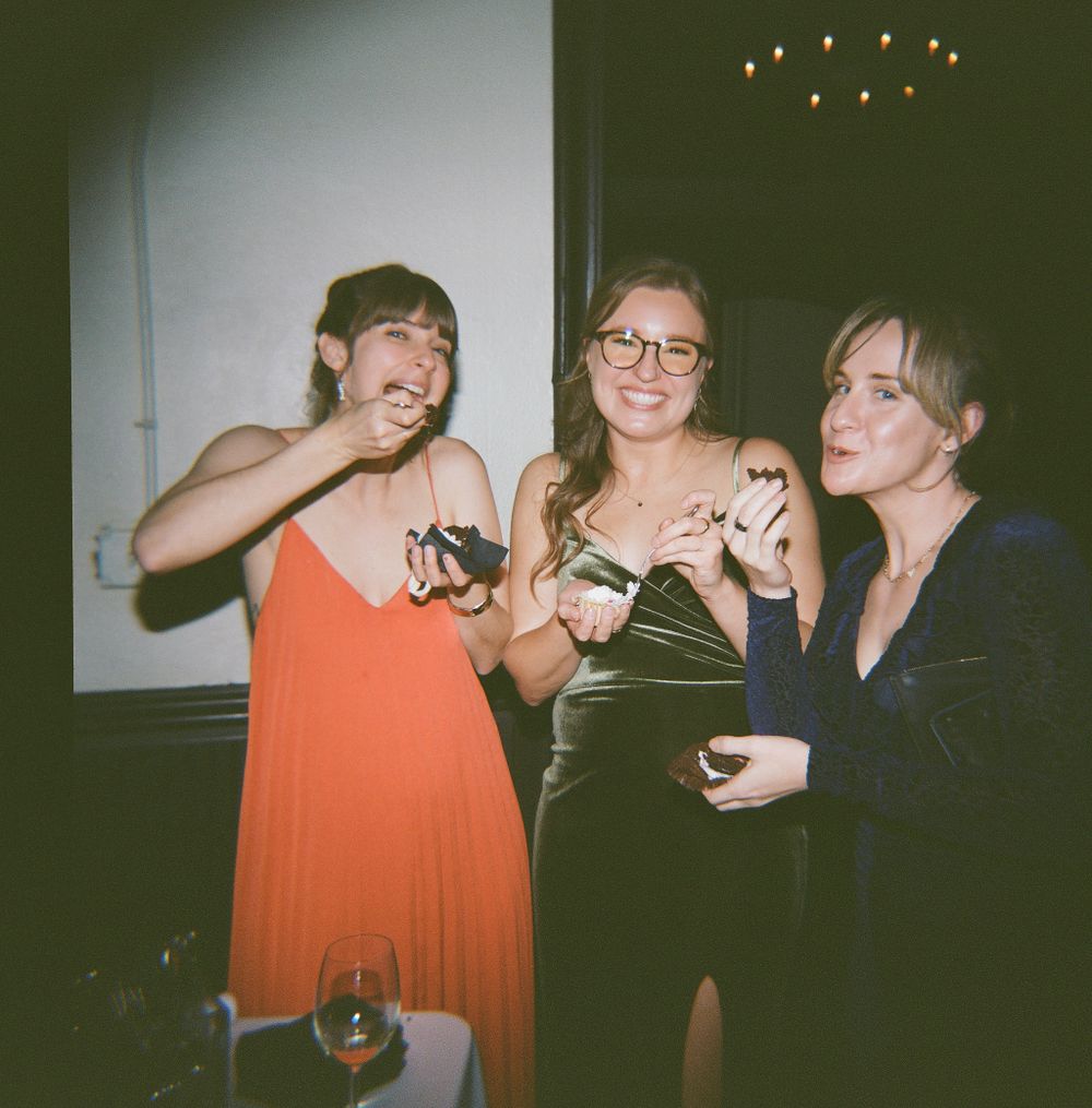 Three wedding guests sharing laughs and drinks at reception party.