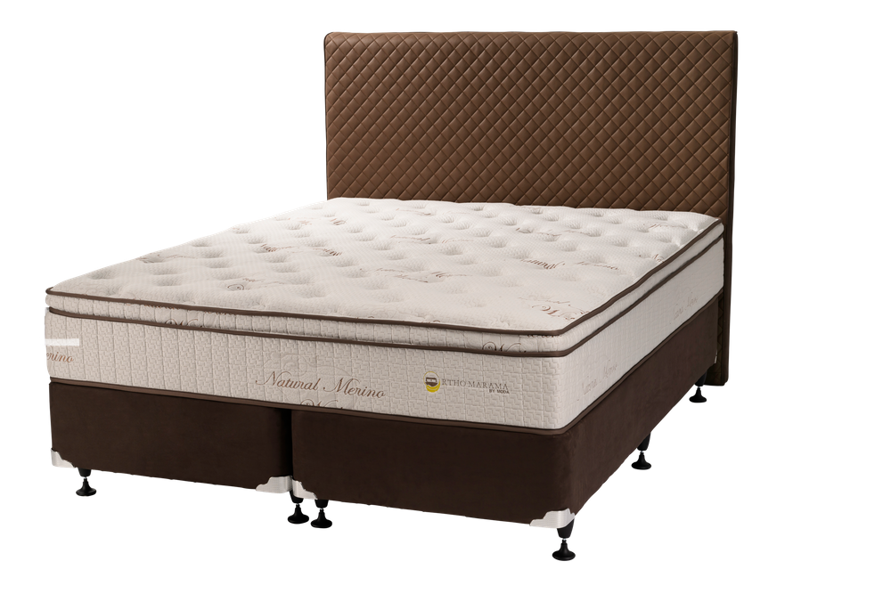 Brown quilted headboard bed with pillow-top mattress on dark background.