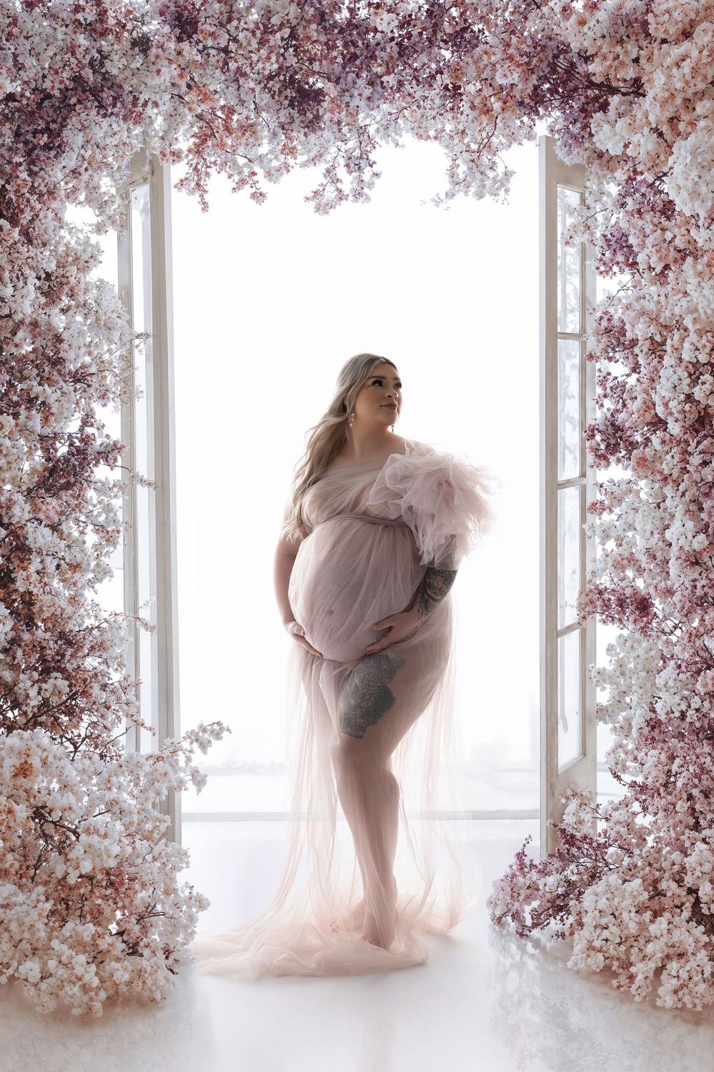 A dreamlike photo series featuring soft pink tulle fabric against a backdrop of delicate cherry blossoms by a window.