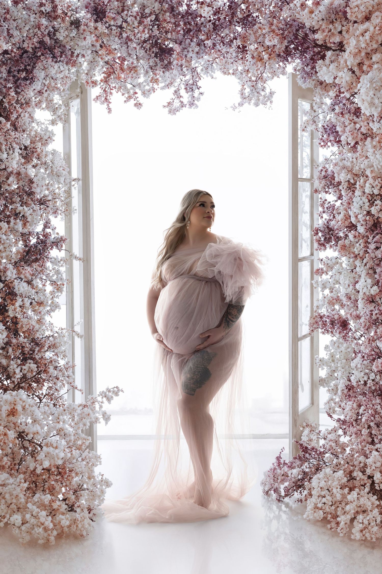A dreamlike photo series featuring soft pink tulle fabric against a backdrop of delicate cherry blossoms by a window.
