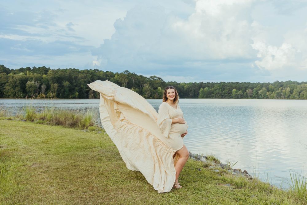 Scenic maternity photos taken at a lakeside location during golden hour.