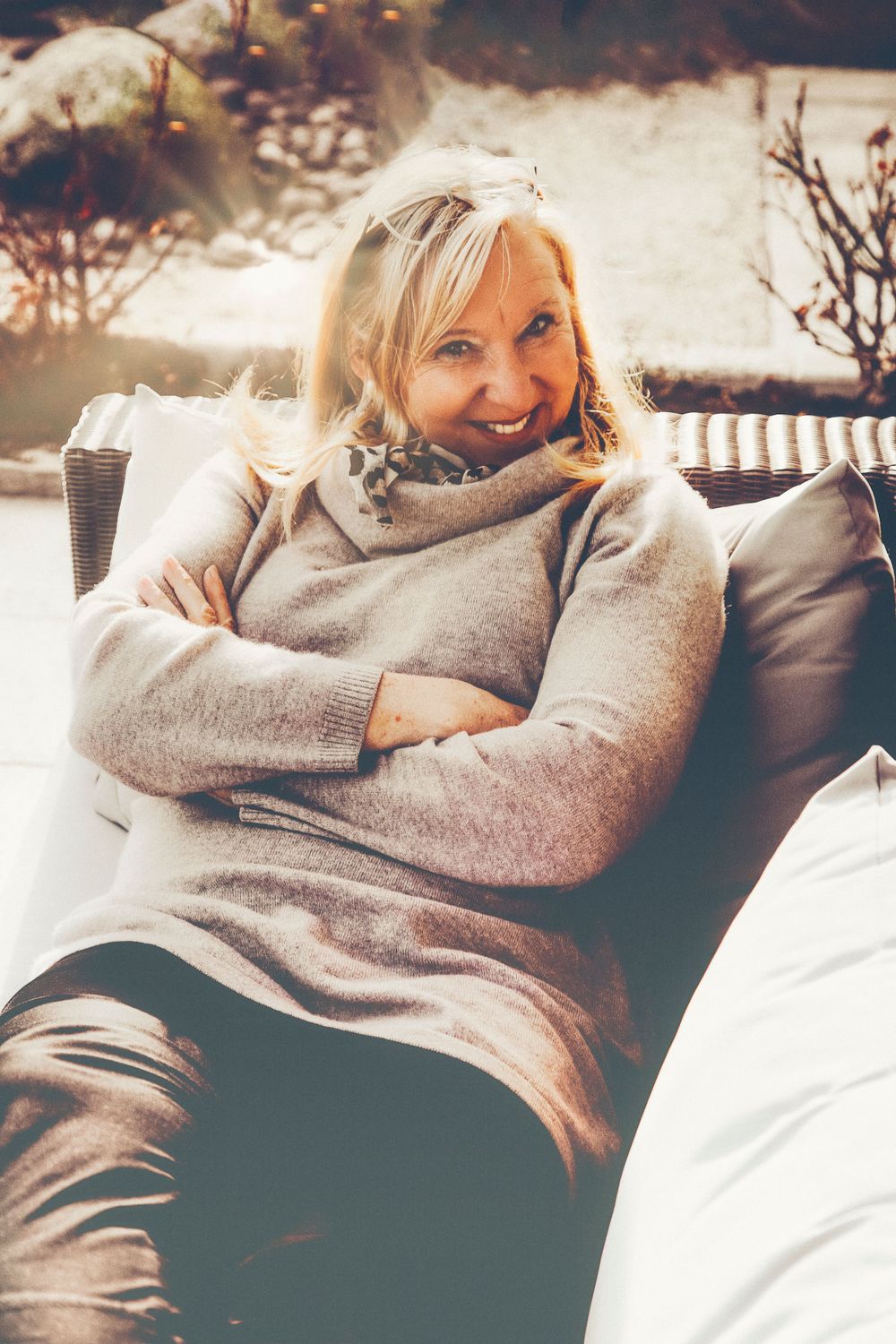 Portrait einer Frau auf einer Sonnenliege im Herbst mit dickem Pullover Homestory