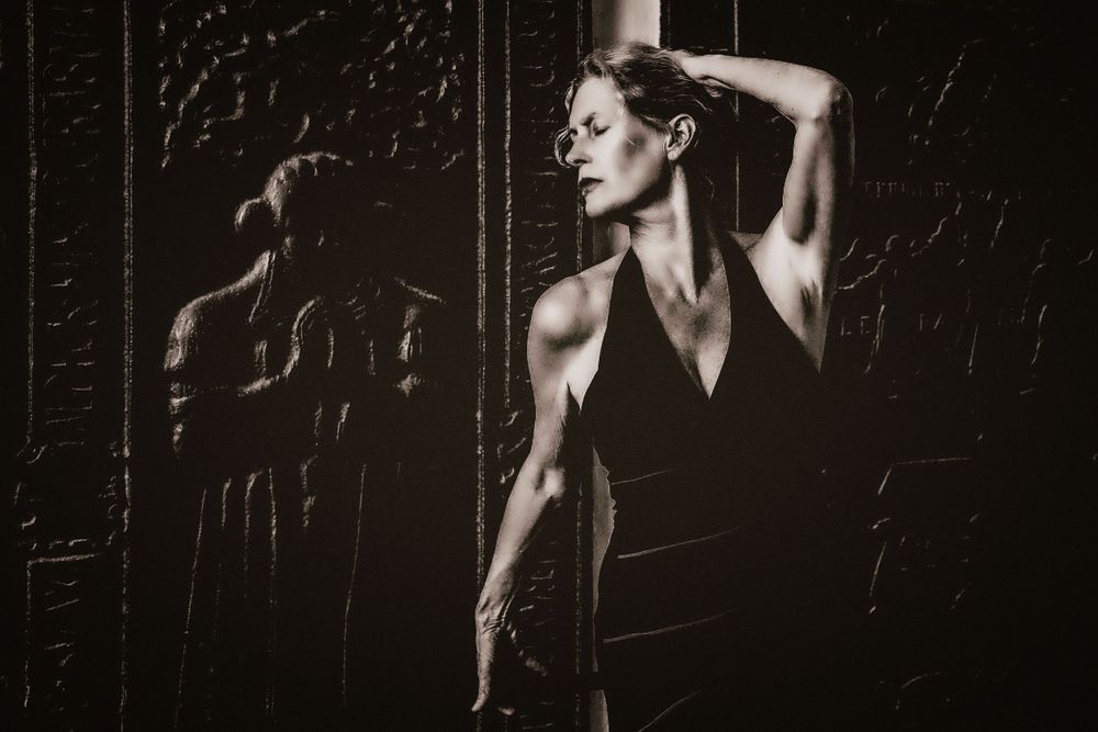 Dramatisches Spiel von Licht und Schatten und ein Portrait einer Frau in einer schauspielerischen Pose an einem Relief  Schloss Bad Arolsen