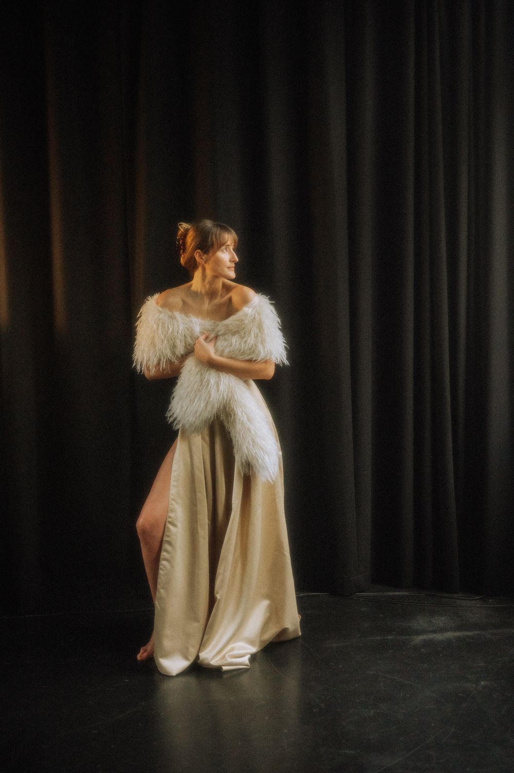 A dramatic dance performance featuring flowing white fabric and ethereal movement on a dark stage.