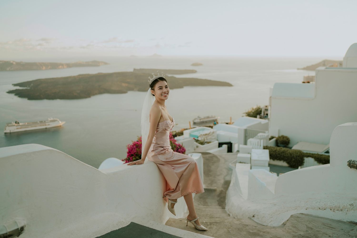 Scenic view of white buildings in Santorini overlooking the Mediterranean Sea at sunset.