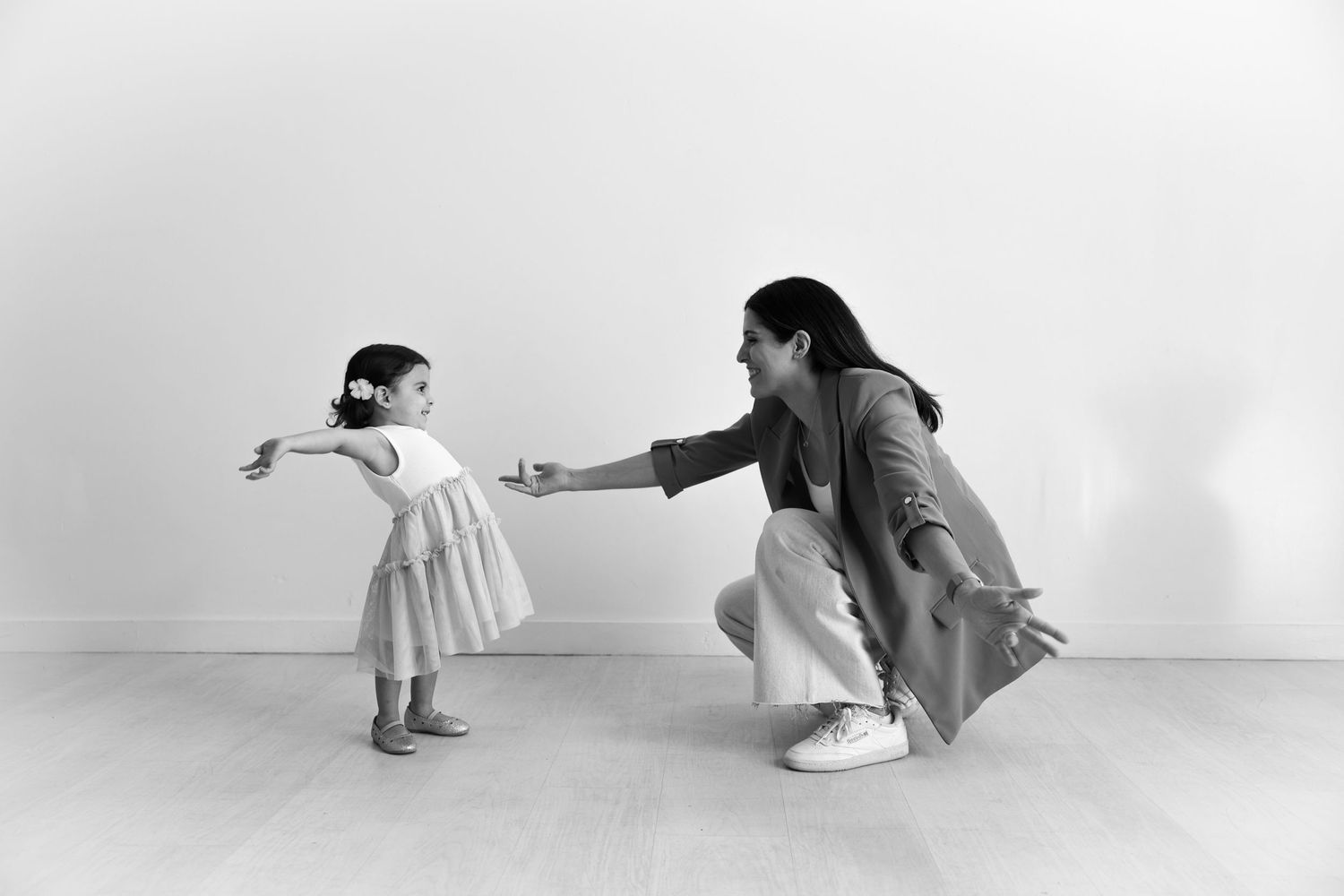 A monochrome portrait of two people dancing together in a minimalist white studio setting at the Lumen Room in Austin, TX.