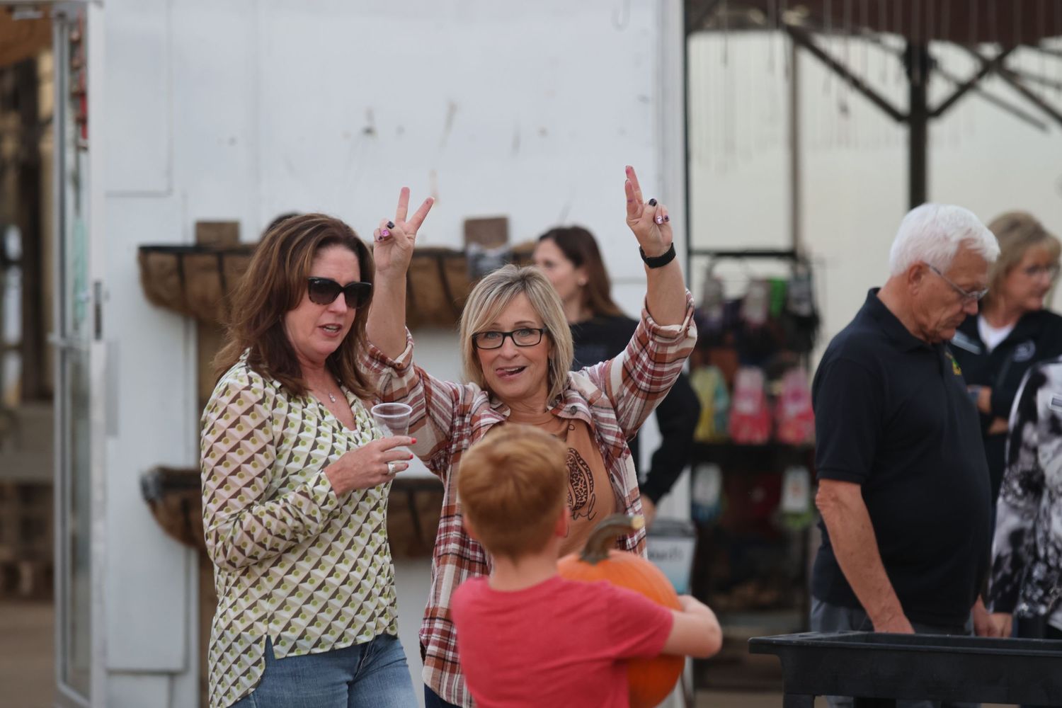People raising their hands in celebration at an outdoor gathering.