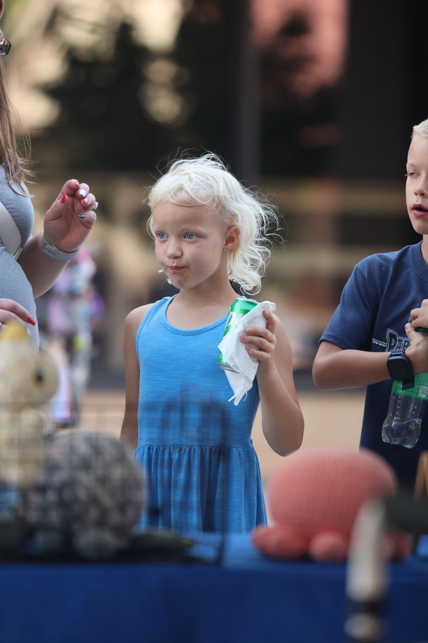 A summer fair scene with cotton candy and treats on a blue table.