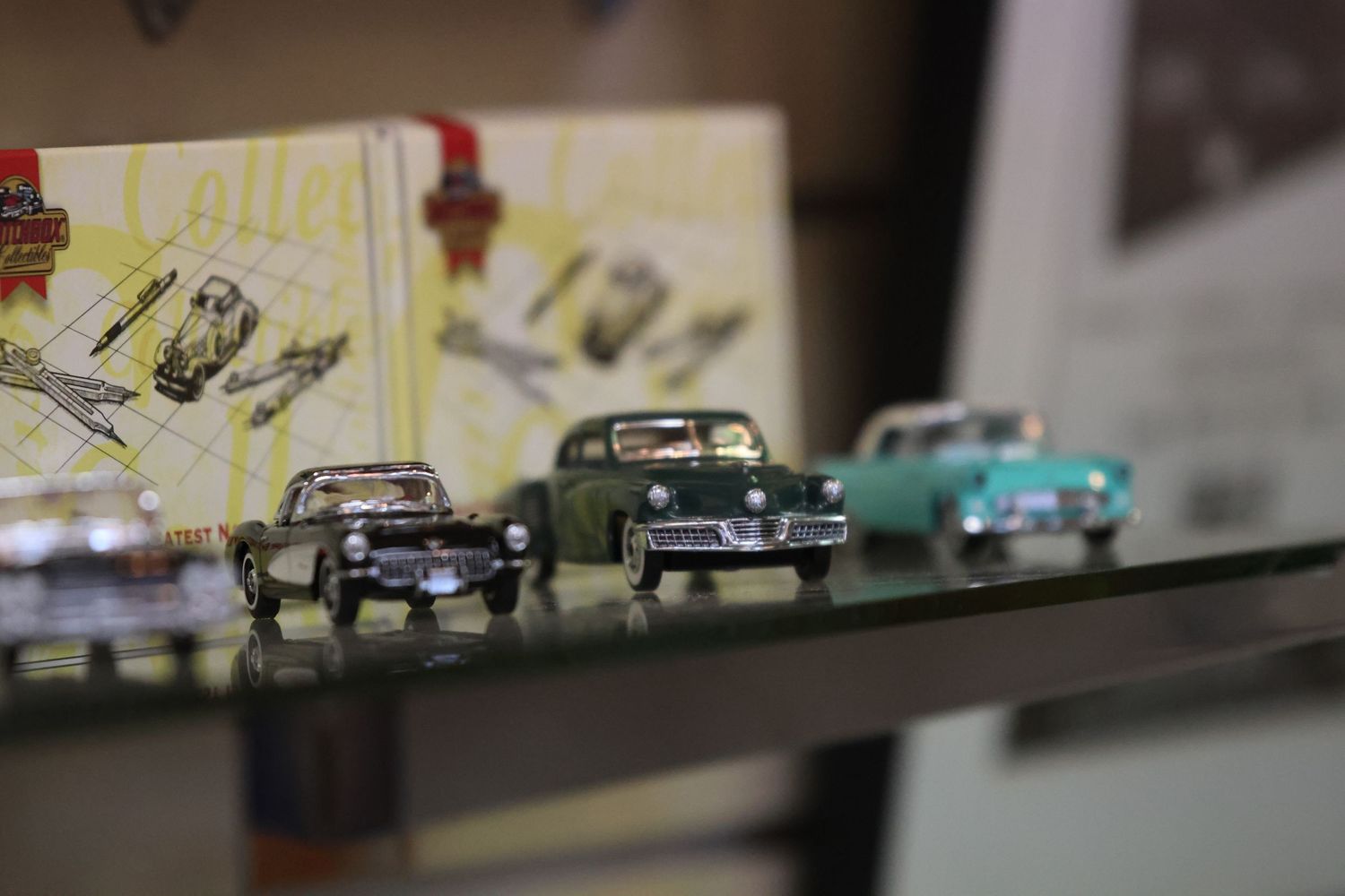 Collection of vintage toy cars displayed on a shelf.