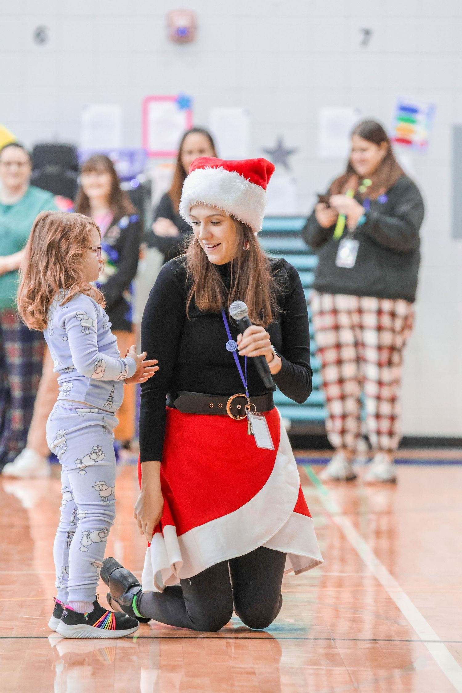 A holiday performance interaction on a gymnasium floor with festive decorations.