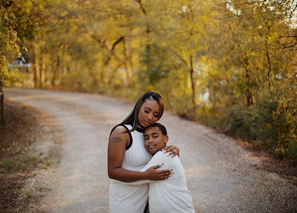 Mother embracing her son on a trail with their eyes closed.