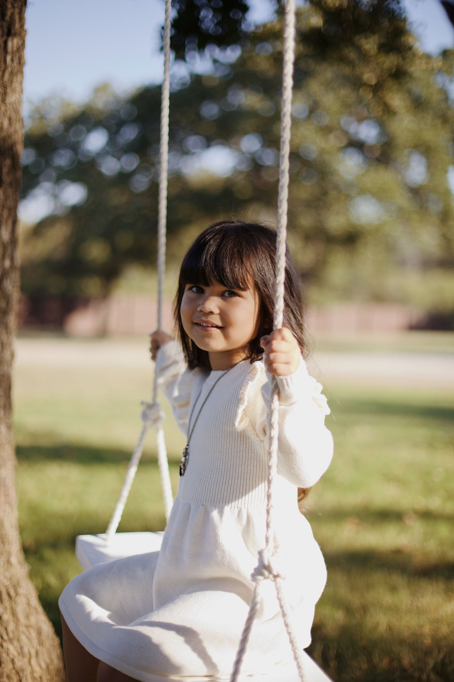 Little girl portrait on a swing.