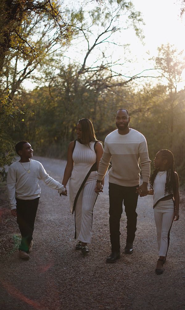 Family holding hands and walking during golden hour.