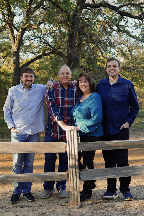 Family portraits near a fence.