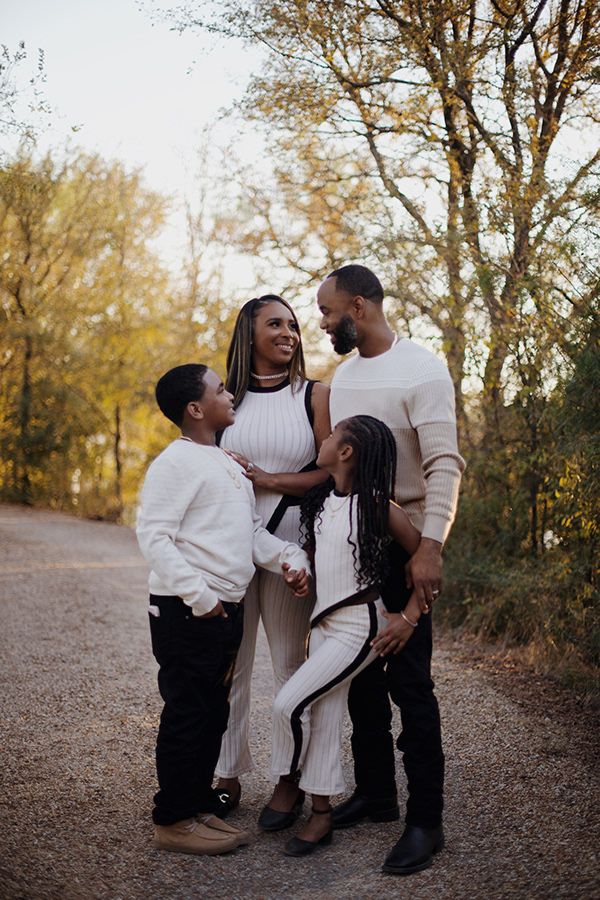 Family holding hands and looking at each other during golden hour.