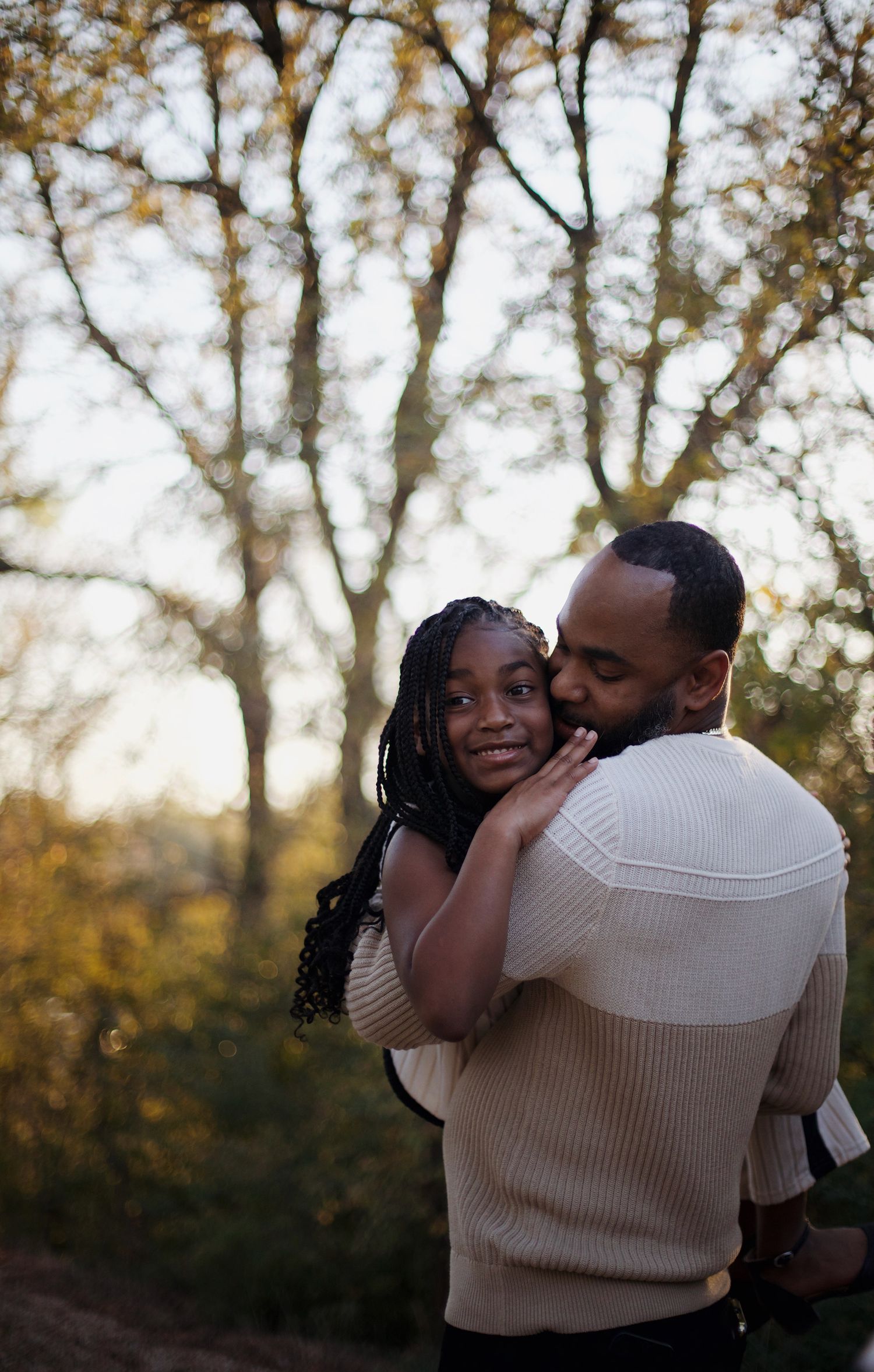 A father holding his daughter and hugger her.