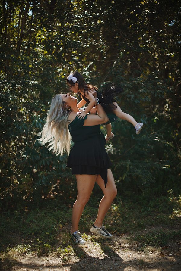 Mother holding up her daughter.