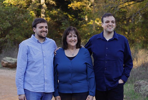 A mother and her two sons smiling.
