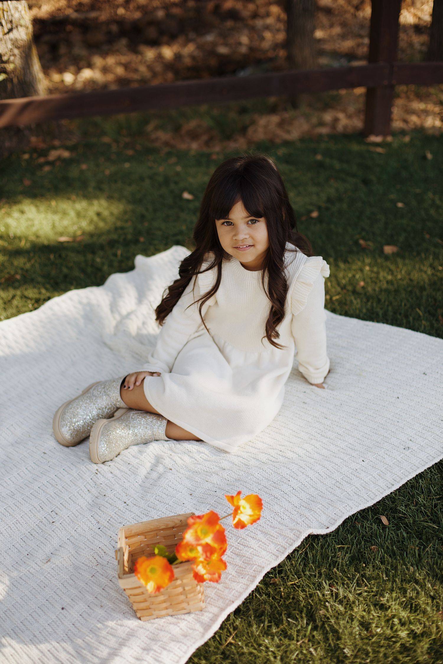 Portrait of little girl sitting on a picnic blanket.