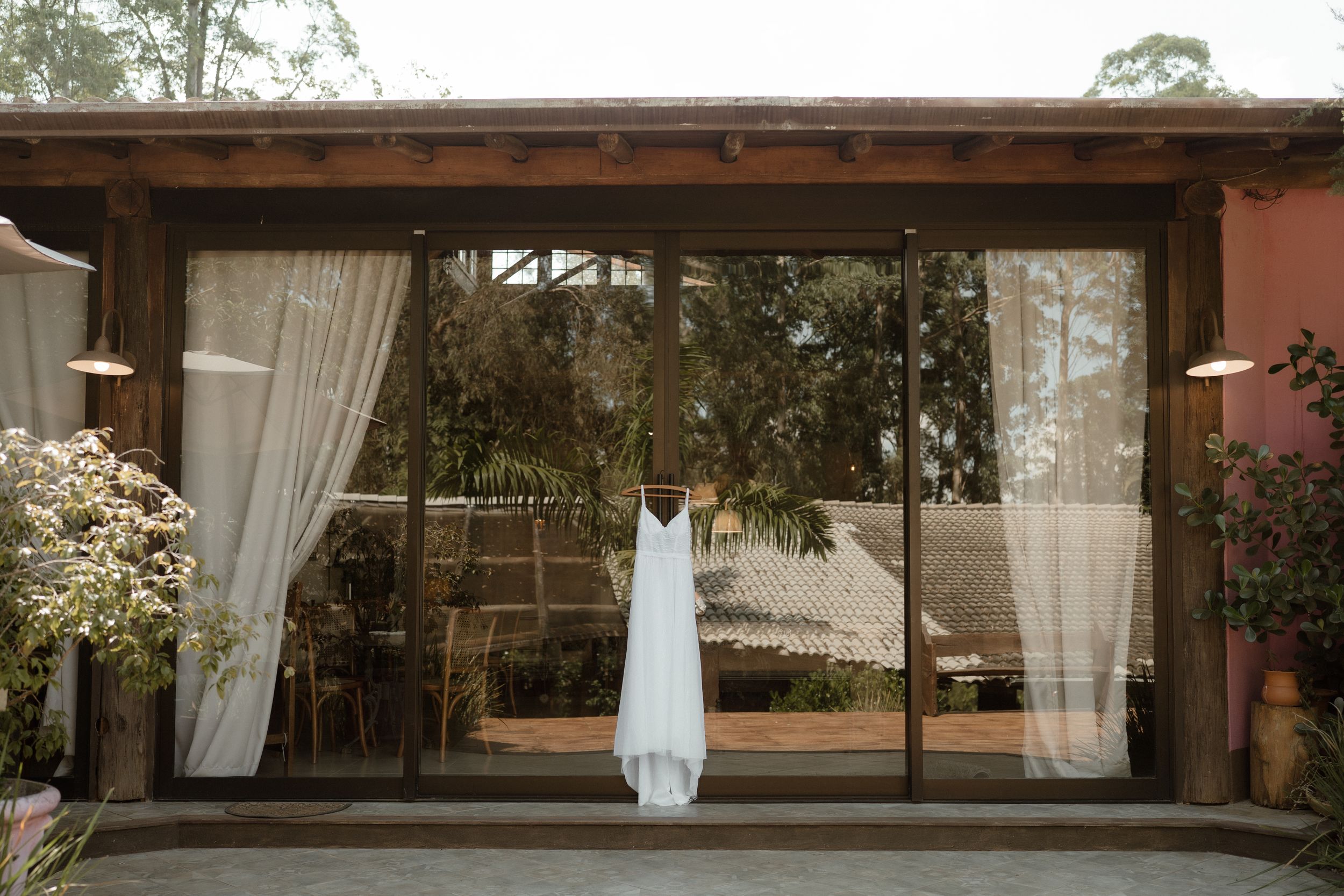 Long rustic outdoor venue with white curtains and natural lighting.