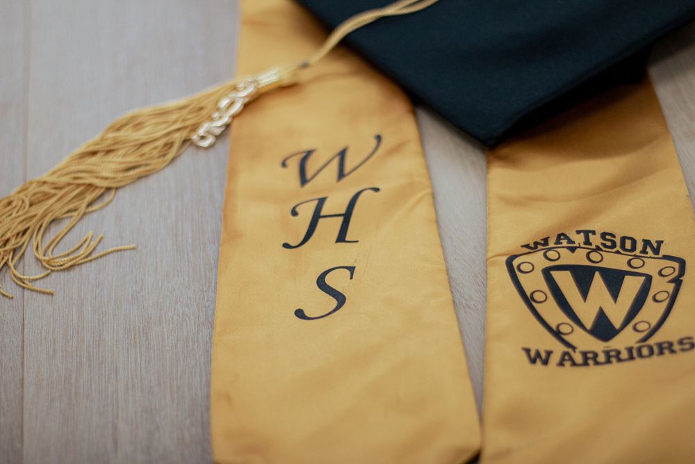 Gold graduation stole with WHS monogram and Walton Warriors logo embroidered in black on tan fabric.