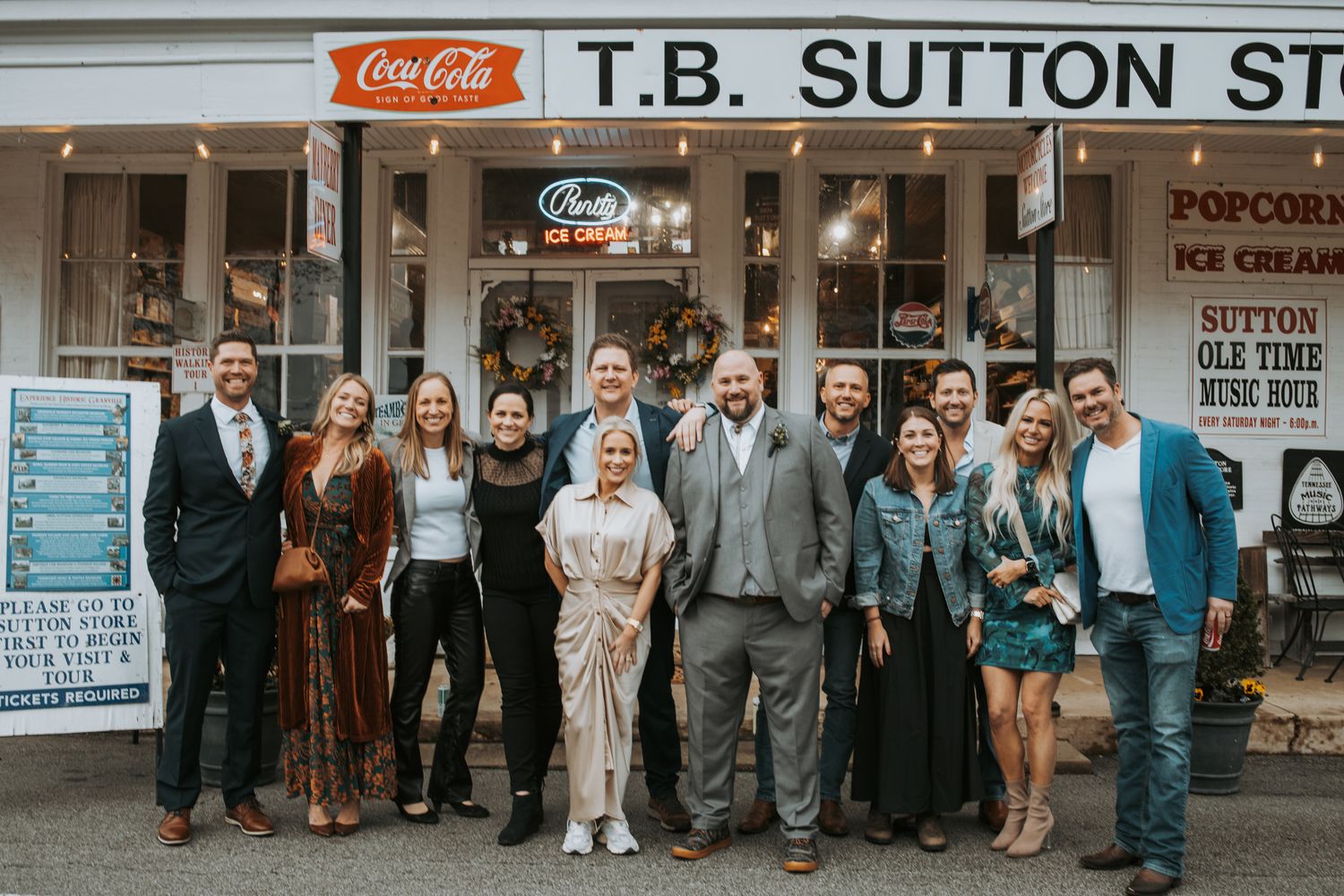 Wedding photography of wedding guests in front of picturesque shop.