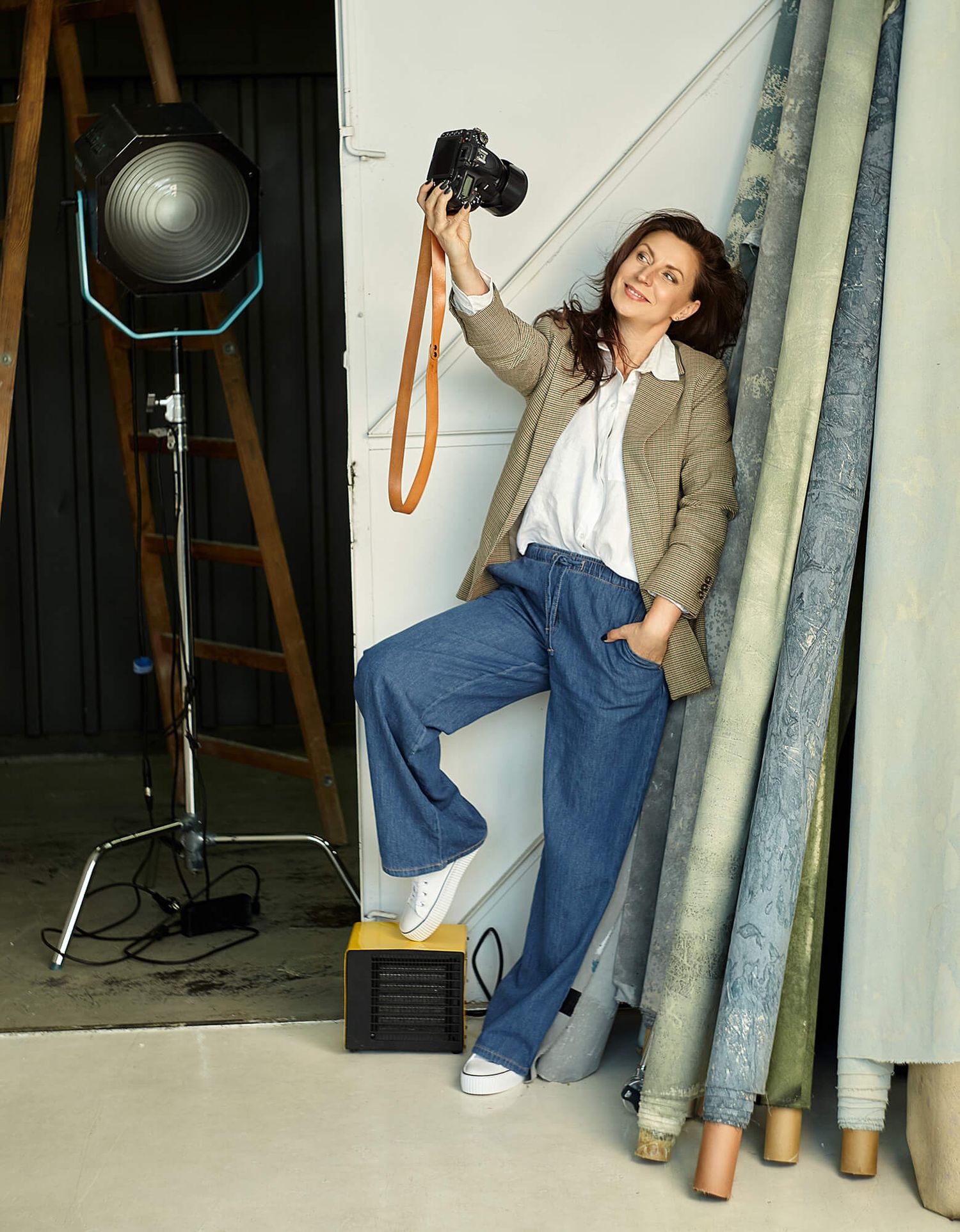 Aneta Ludwig z aparatem w dłoni w stylowym studio fotograficznym – fotografia portretowa i brandingowa premium.