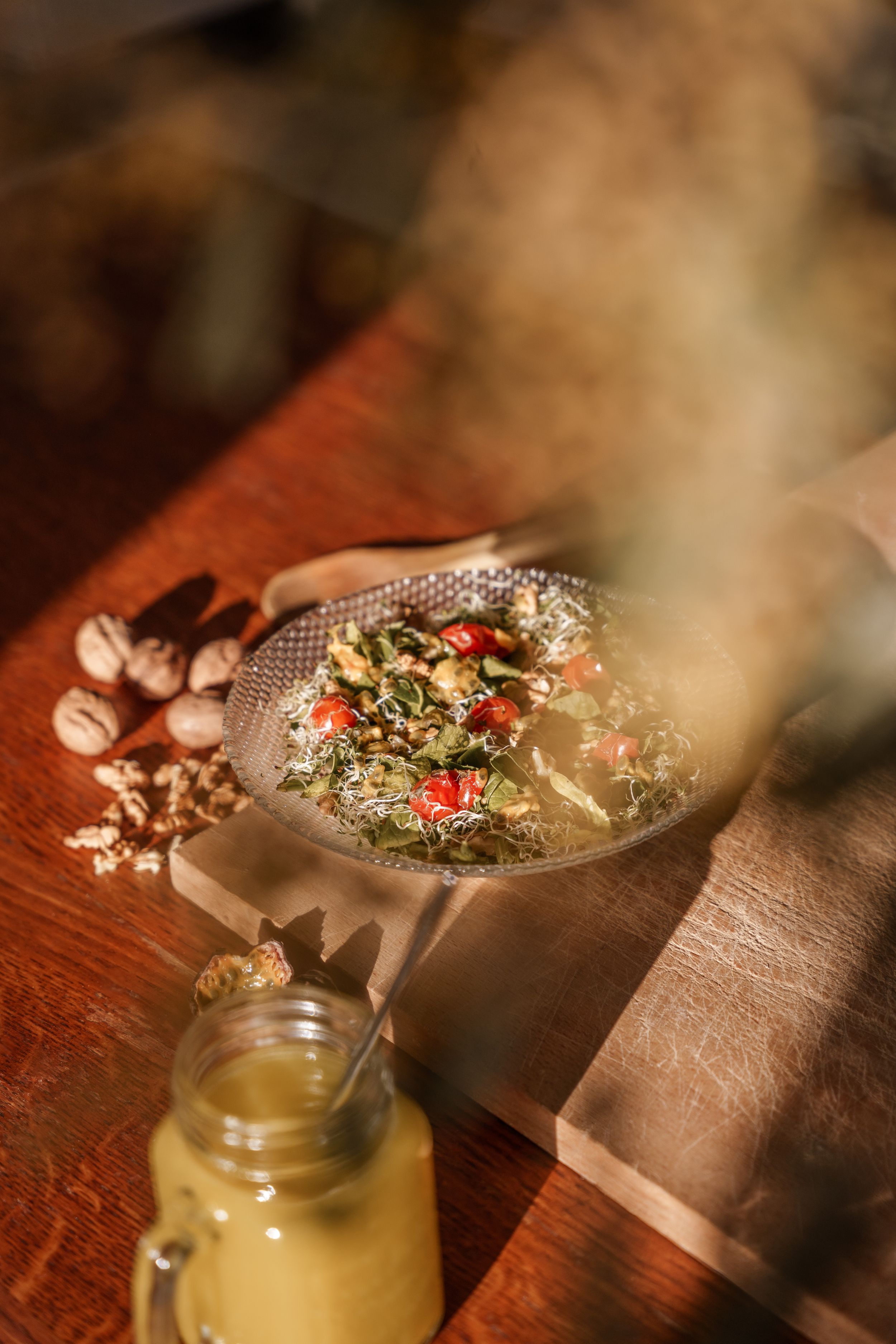 A rustic wooden table setting with dried flowers and a mason jar filled with a refreshing beverage.