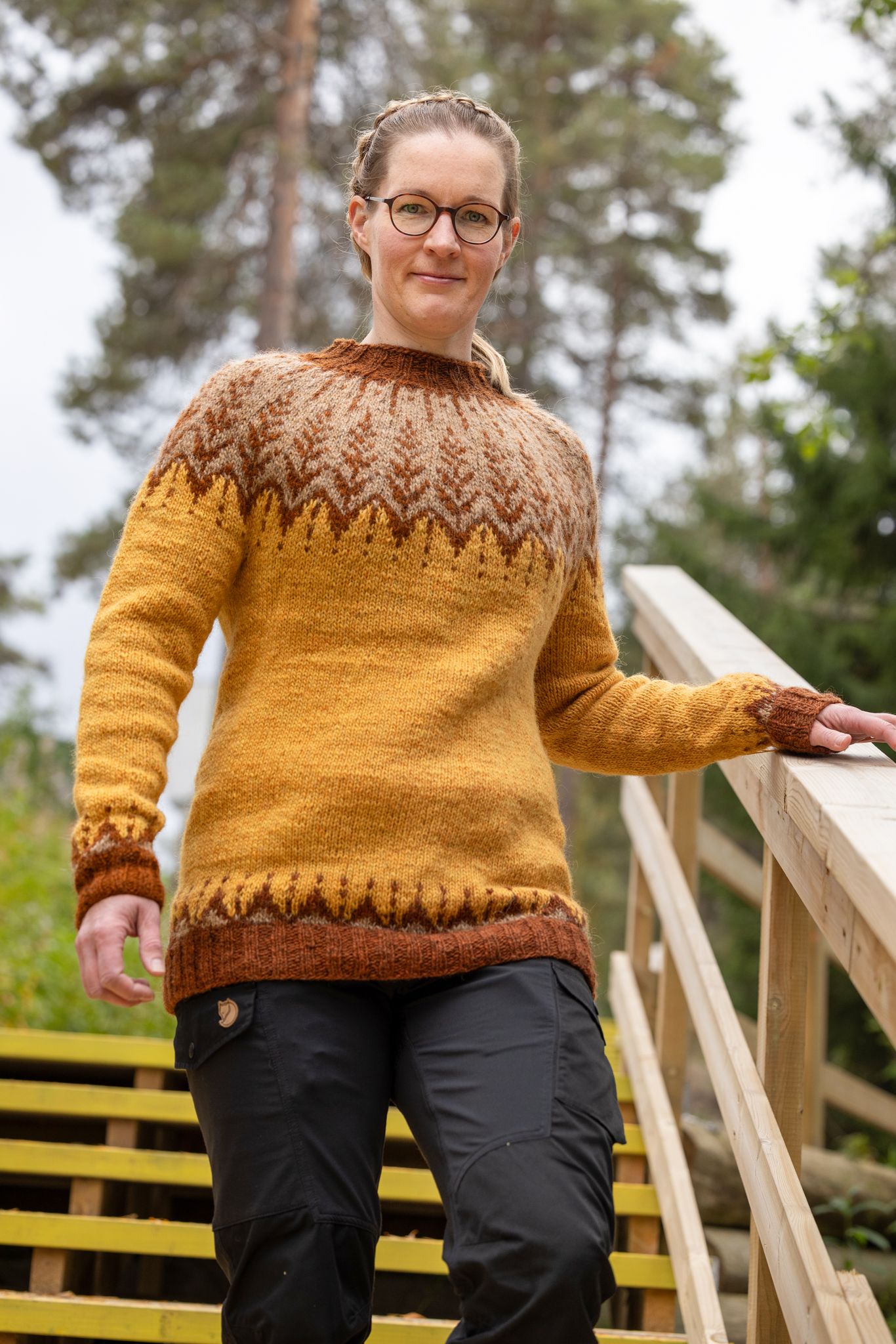 Neulepuseroon pukeutunut nainen laskeutuu ulkoportaita.