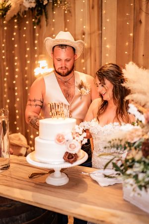 Romantic wedding cake cutting sequence with sparklers and string lights creating a warm, glowing ambiance.