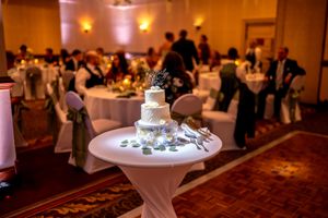 Elegant wedding reception venue with round tables, white linens, and warm ambient lighting creating a romantic atmosphere.