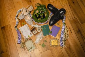Wedding details scattered across wooden flooring including flowers, papers, and decorative items.