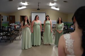 Bridesmaids wearing mint green dresses gather in an indoor venue for a wedding celebration.