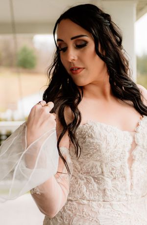 Beautiful lace wedding dress details with sheer sleeves and delicate embellishments.