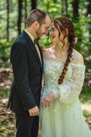 Intimate woodland wedding portraits showing tender moments between a couple in formal attire.