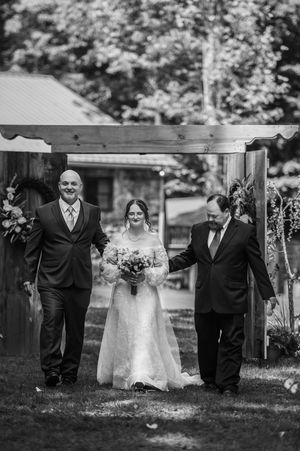 Black and white wedding ceremony photo under outdoor pavilion.