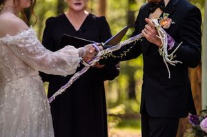 A line of groomsmen in formal attire perform a sabering ritual with champagne bottles in a celebratory scene.