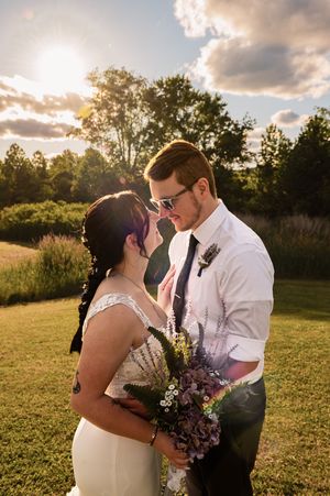 Wedding couple poses in golden evening light with dramatic sky.