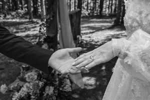 Romantic forest wedding photo series showing newlyweds embracing among sunlit trees.