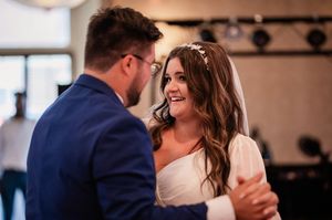 A candid moment of a couple sharing a joyful laugh during their first dance.