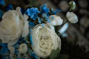 Delicate white roses and blue floral arrangements creating an elegant wedding decoration display.