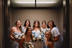 Wedding party posing in dramatic lighting against dark interior backdrop.