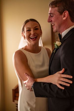 Candid moment of joy shared between newlyweds in formal attire.