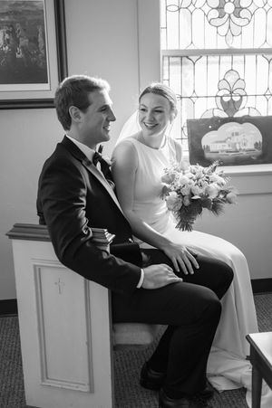 Wedding couple sharing an intimate moment on a church pew.